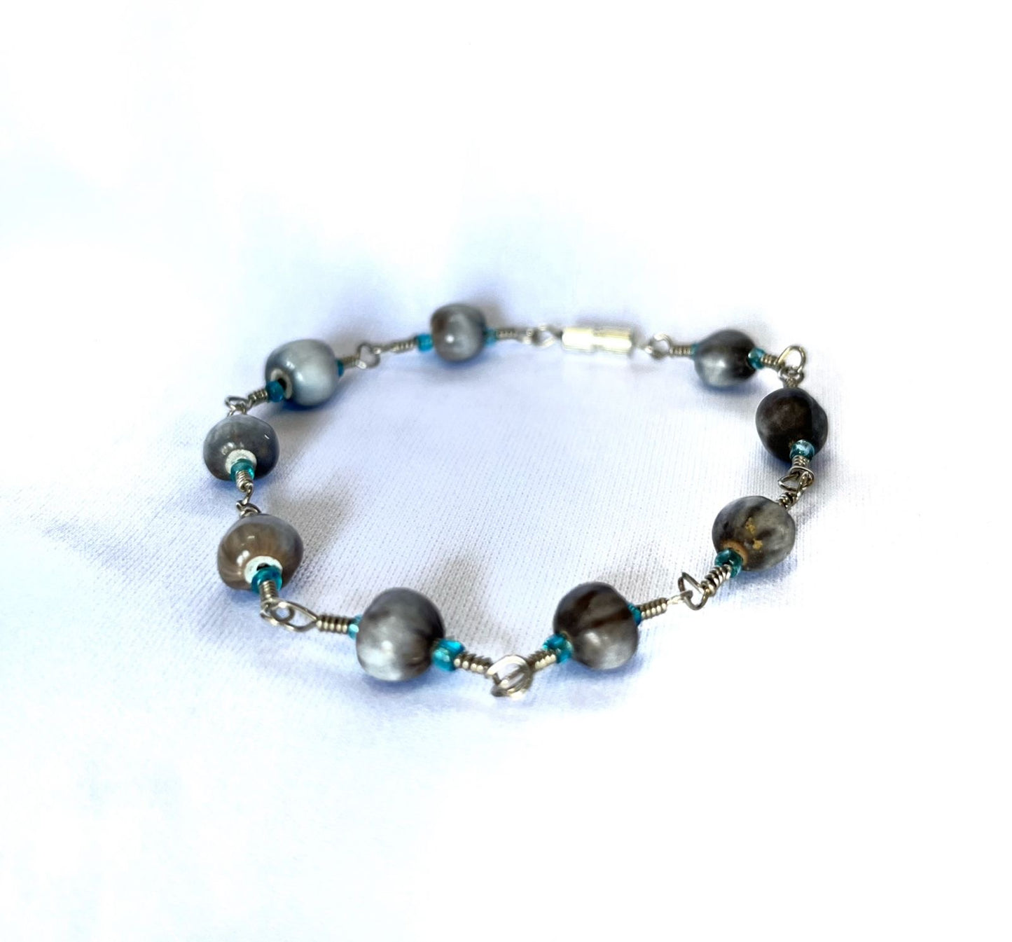 Brazalete metálico con perlas grises