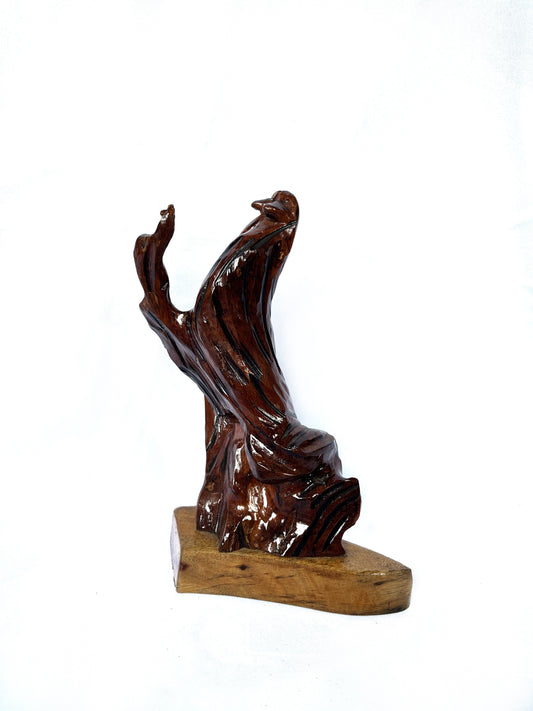 Estatua de madera con pájaro en un tronco