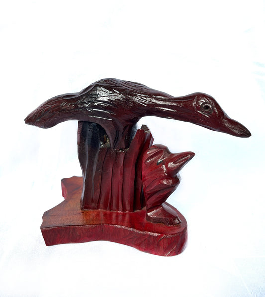 Estatua de madera con un pato rojiza